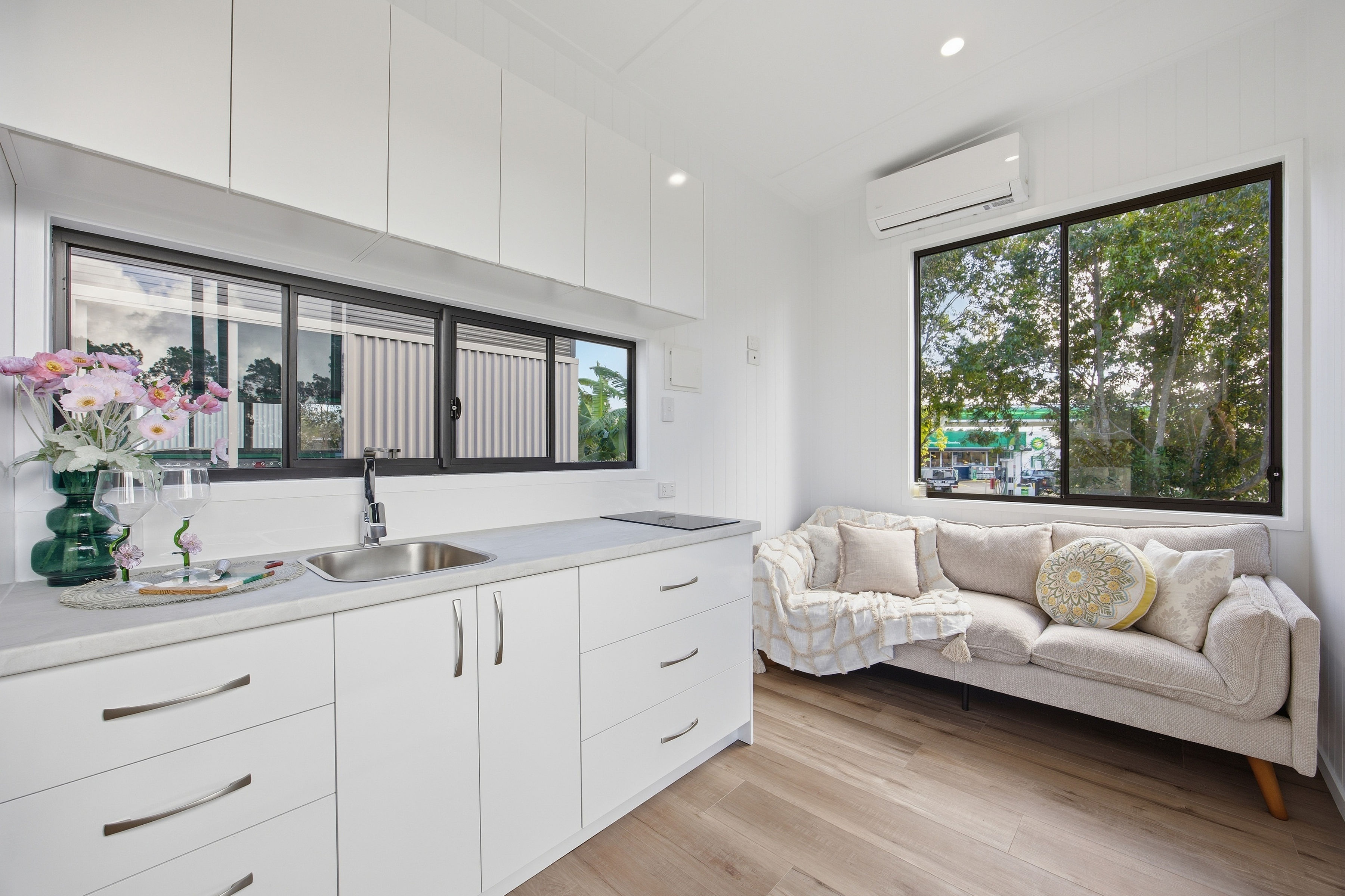 Kookaburra 9 interior — white kitchen and lounge with timber floors