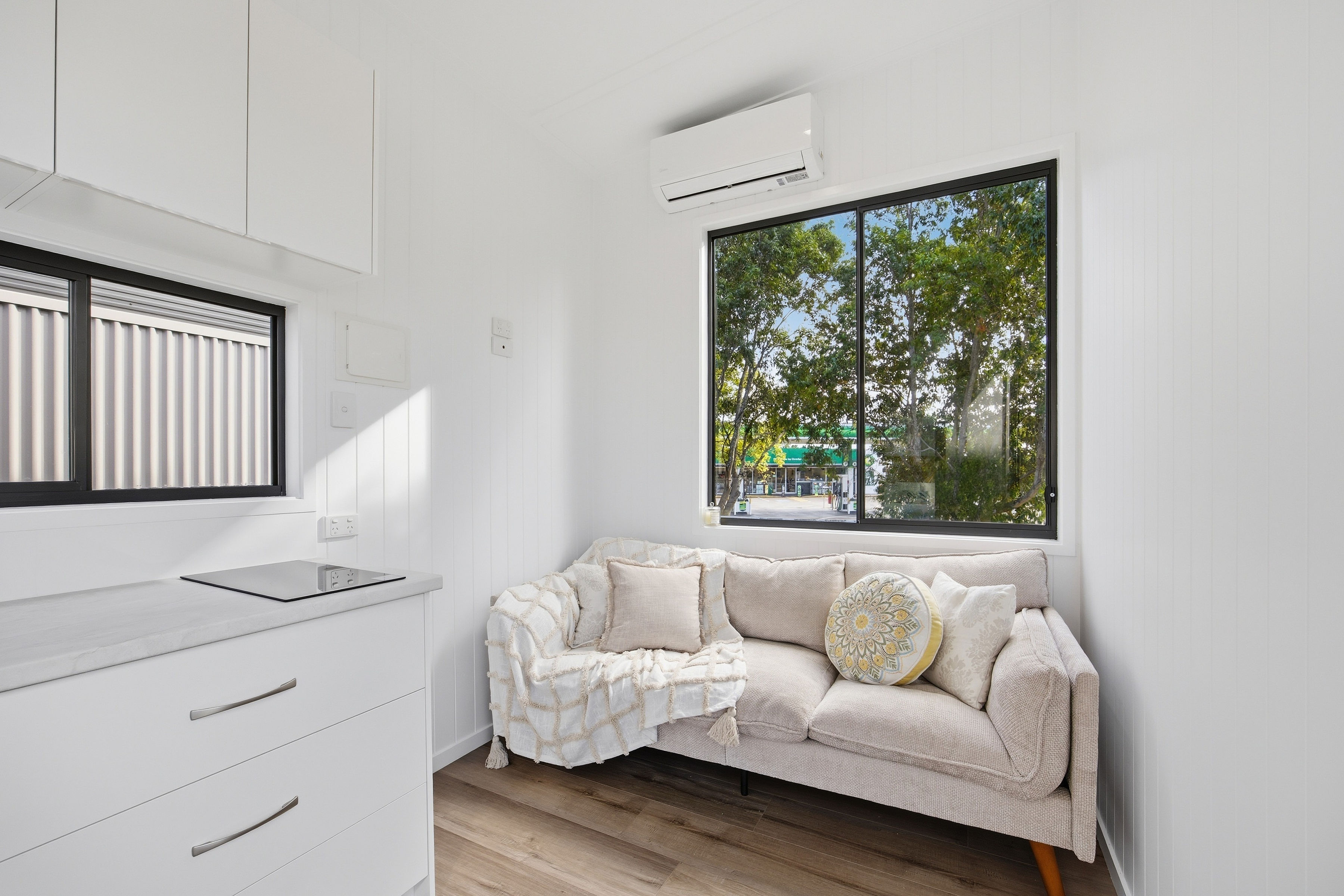 Bright tiny home lounge with sofa and garden outlook